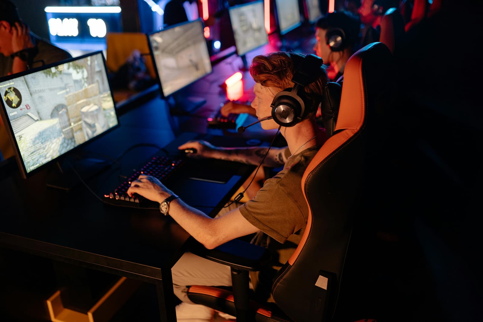 Esports player at a row of gaming PCs in a competitive arena